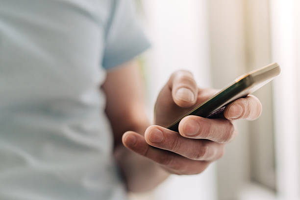 istock male hand holding smartphone 498698496
