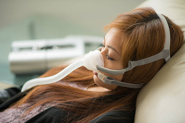 CPAP Apnea Medical Sleep close up picture of a asian young woman sleeping wearing an apnea mask on black background sleep apnea photos stock pictures, royalty-free photos & images