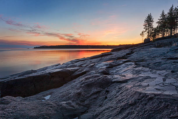 istock Lake granite shore with ancient petroglyphs aginst bright sunset background 498703889