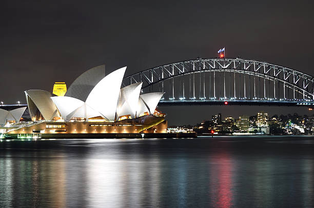 сиднейский оперный театр и мост ночью с видом на гавань - sydney opera house sydney harbor opera house bright стоковые фото и изображения