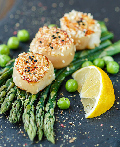 istock Scallops with sesame seeds, asparagus, lemon and green peas 498708290