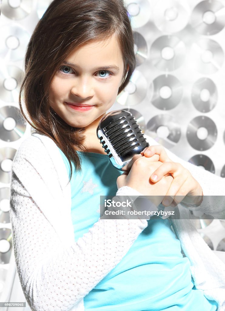 I love music. Child, teen, girl, singing into a microphone, a small singer Activity Stock Photo