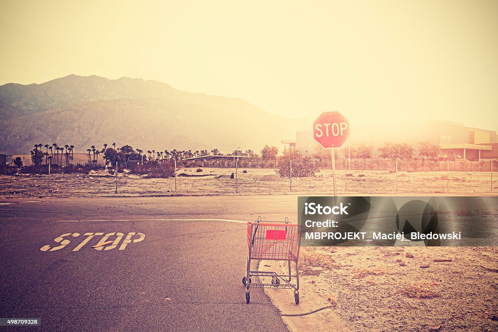 Retro toned empty shopping trolley left on street at sunset. Retro toned empty shopping trolley left on street at sunset, Palm Springs, USA. Stop Sign Stock Photo