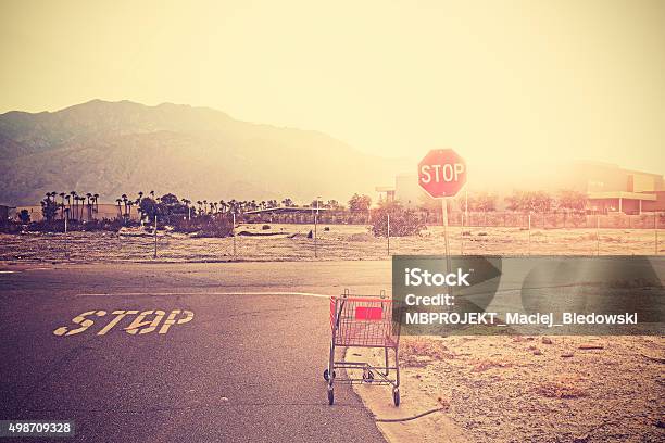 Retro Toned Empty Shopping Trolley Left On Street At Sunset Stock Photo - Download Image Now