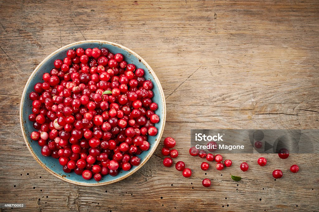 bowl of cowberries bowl of cowberries on old wooden table Cranberry Stock Photo