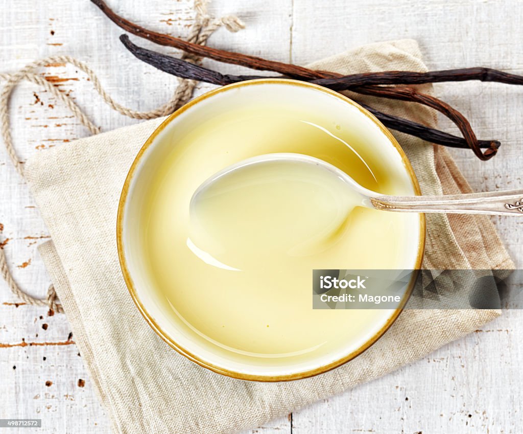 bowl of vanilla sauce bowl of vanilla sauce on white wooden table, top view 2015 Stock Photo