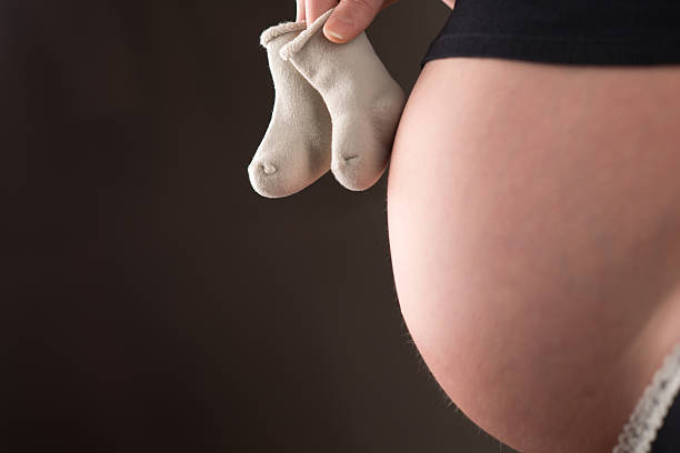 istock Pregnant woman's belly with baby socks 498714486