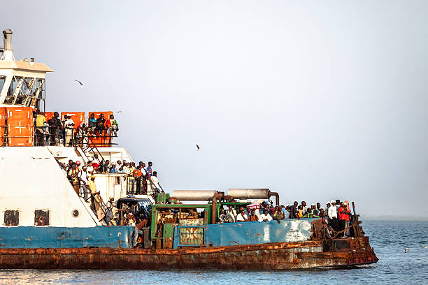 Banjul, The Gambia - February 21st 2011: Old rusty ferry full of local passengers is crossing river Gambia from Barra to Banjul.