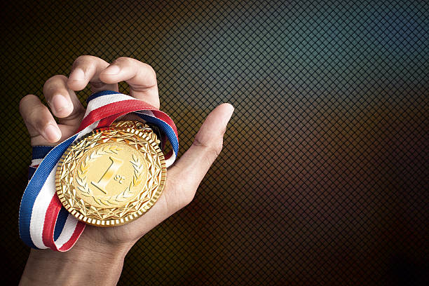 hand holding up a gold trophy stock photo