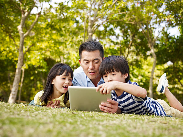 azjatycki ojca i dzieci za pomocą komputera typu tablet na świeżym powietrzu - father digital tablet asian ethnicity daughter zdjęcia i obrazy z banku zdjęć