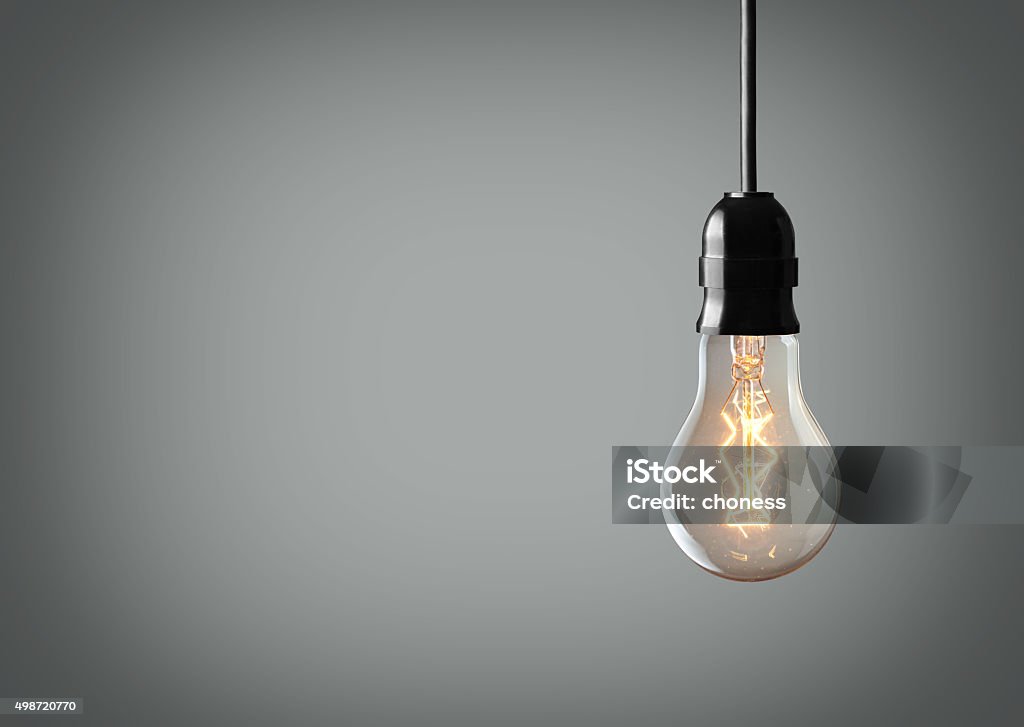 Vintage bulb Vintage hanging light bulb over gray background Light Bulb Stock Photo