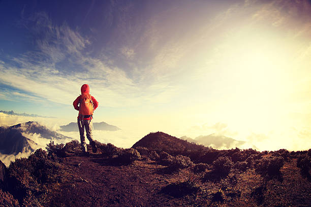 istock young woman hiker on beautiful rolling clouds mountain peak 498723200