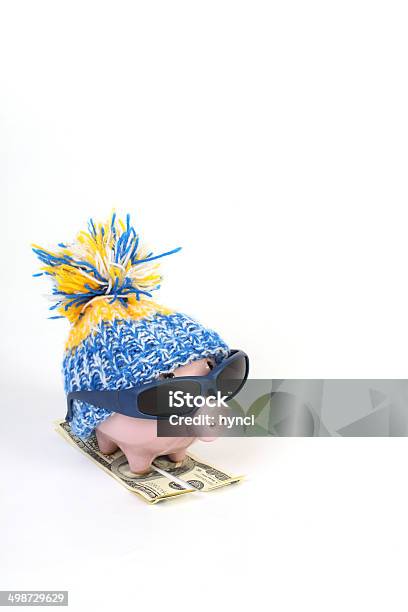 Piggy Bank With Hat Standing On Skies Of Hunderd Dollars Stock Photo - Download Image Now