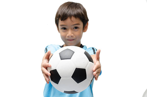 istock Little boy holding football on white background 498730203
