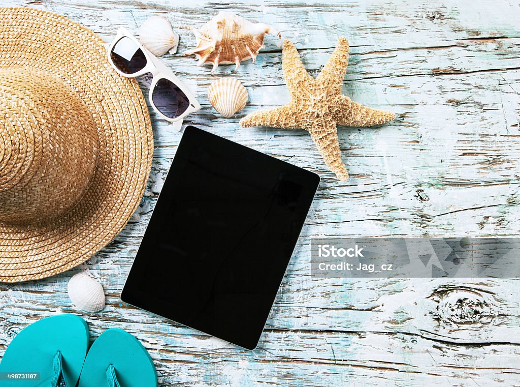 Summer concept with tablet and accessories Top view of summer accessories and blank tablet on wooden planks Beach Stock Photo