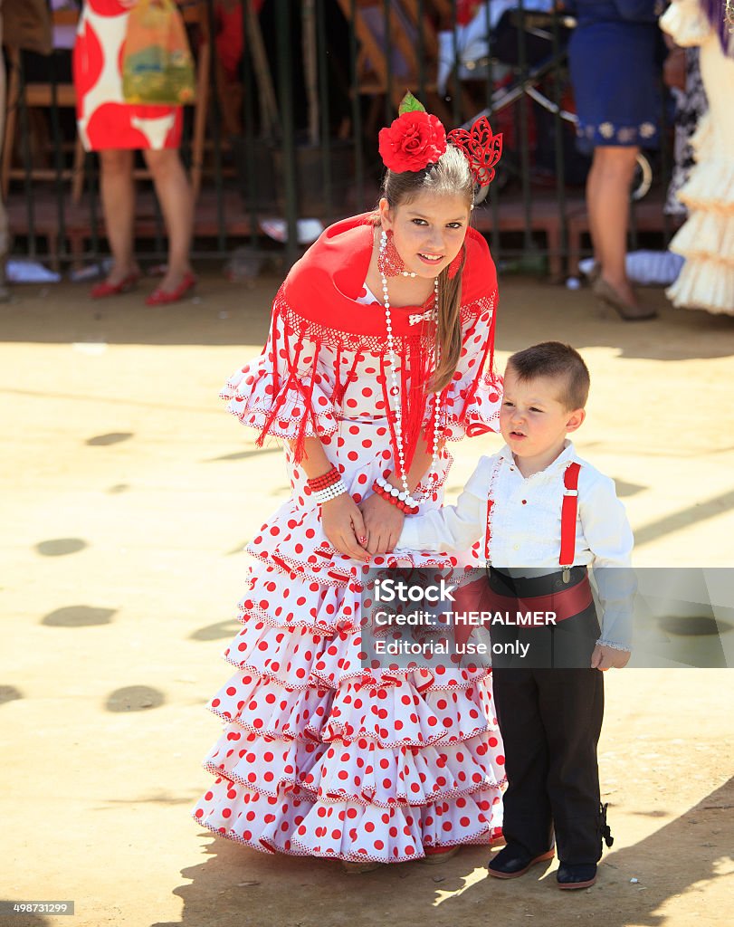 Children enjoying the April Fair Seville, Spain - May 6, 2011: There is something for everyone during the fair, specially for the little ones, girl and boy wearing traditional costumes during the big party. Traveling Carnival Stock Photo