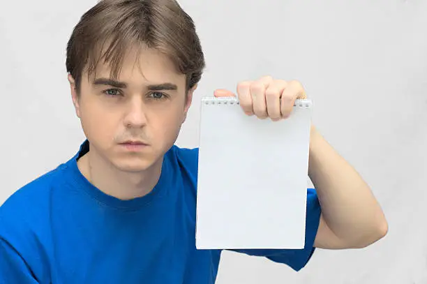 Guy looking with white paper  notebook