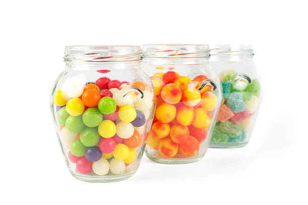 istock Glass jars filled with different colorful candies isolated on white 498732073