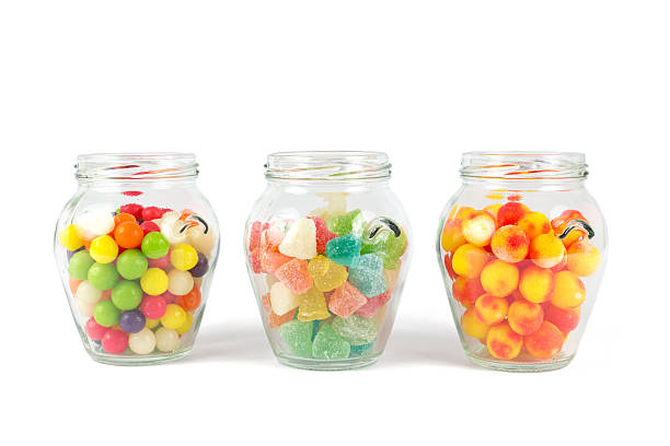 istock Glass jars filled with different colorful candies isolated on white 498732077