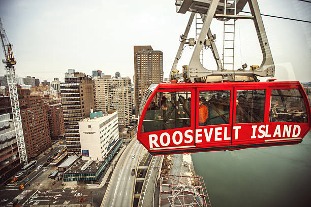 New York, USA - January 1, 2014: Aerial Tramway from Roosevelt Island to New York City, people inside the cabin, making photos of New York from above.