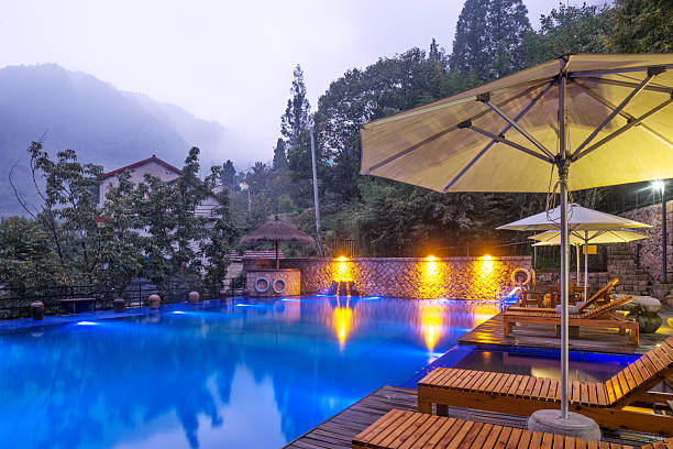 istock Umbrella chair in hotel pool resort with sunset 498734072