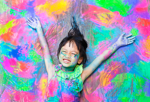 little girl covered in colorful paint