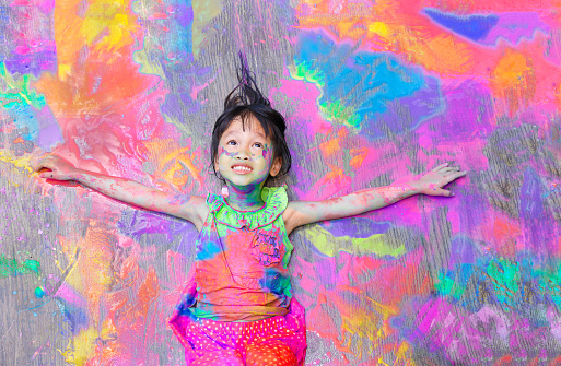 little girl covered in colorful paint