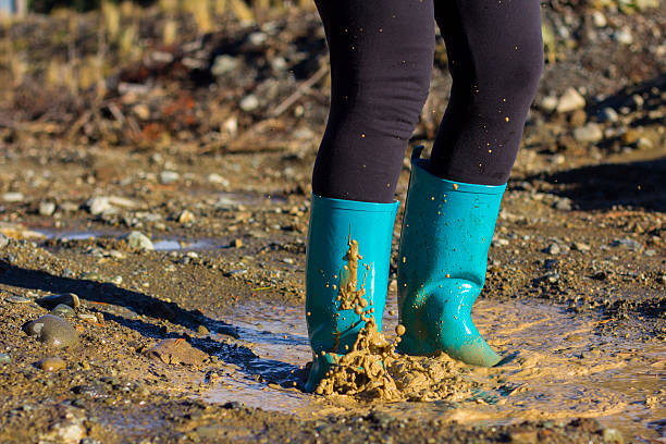 istock Turquoise gumboots splashing in a puddle 498735847
