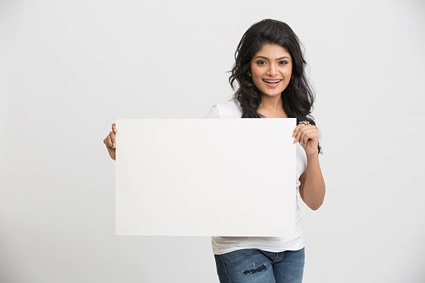 istock Happy young pretty Indian woman holding a blank billboard 498736246