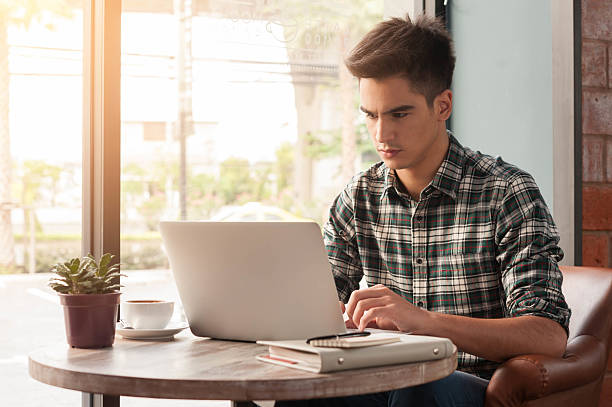 istock Businessman using laptop with tablet and pen on wooden table 498737870