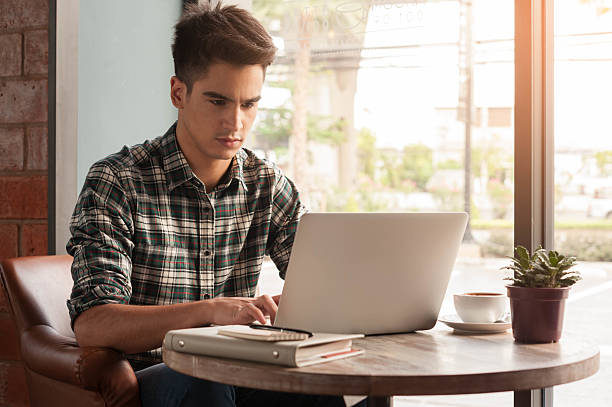 istock Businessman using laptop with tablet and pen on wooden table 498737900