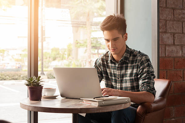 istock Businessman using laptop with tablet and pen on wooden table 498737930