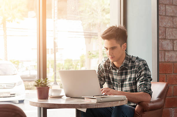 istock Businessman using laptop with tablet and pen on wooden table 498738086