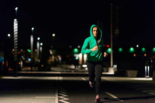 Woman jogging in the city at night