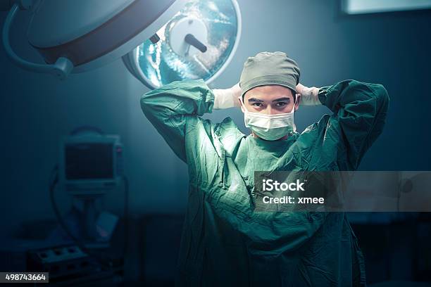 Surgeon In Theatre Getting Ready To Operate On A Patient Stock Photo - Download Image Now
