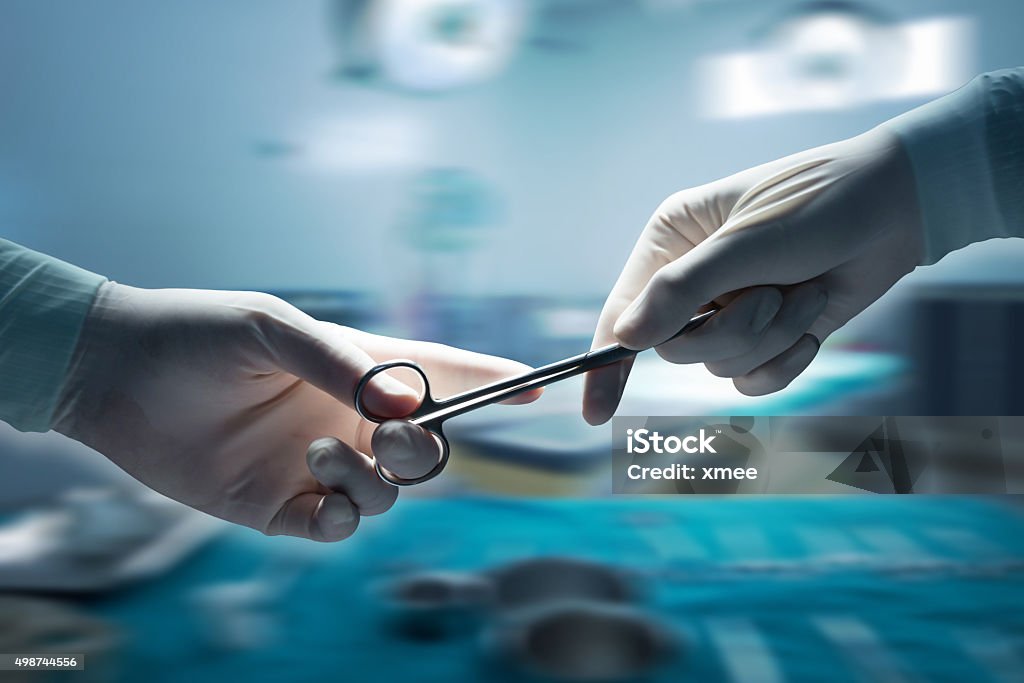 healthcare and medical concept , Close-up of surgeons hands hold healthcare and medical concept , Close-up of surgeons hands holding surgical scissors and passing surgical equipment , motion blur background. Surgery Stock Photo