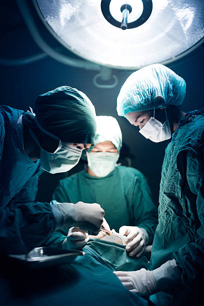 medical team performing de la cirugía - performance surgery doctor men fotografías e imágenes de stock