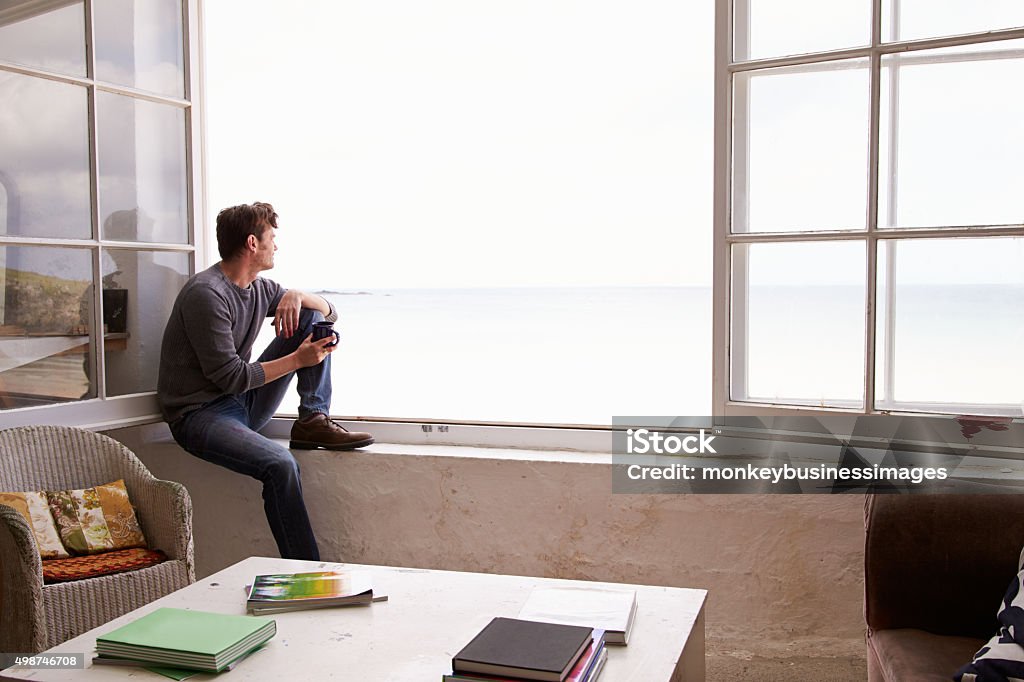 Man Sitting At Window And Looking At Beautiful Beach View Men Stock Photo
