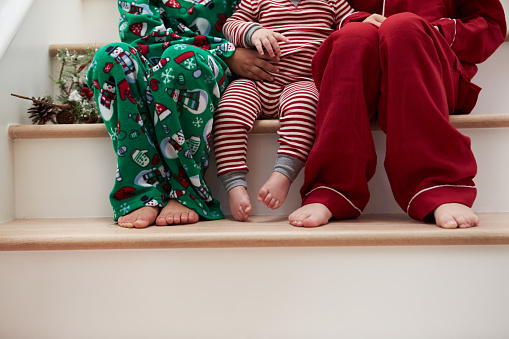 Tres niños en pijama sentado en las escaleras en Navidad photo