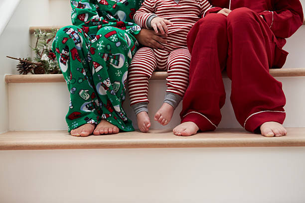 Three Children In Pajamas Sitting On Stairs At Christmas Three Children In Pajamas Sitting On Stairs At Christmas 3 6 months stock pictures, royalty-free photos & images