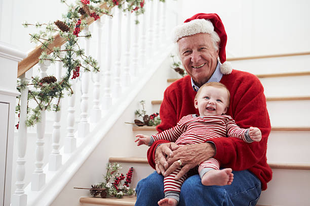 Grandfather With Granddaughter Sits On Stairs At Christmas Grandfather With Granddaughter Sits On Stairs At Christmas old man pajamas photos stock pictures, royalty-free photos & images