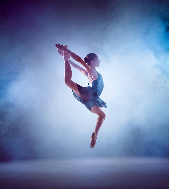 The silhouette of young ballet dancer jumping on a blue