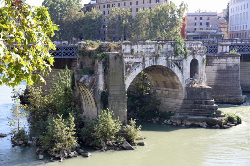 Rome, ancient broken bridge on the Tiber and trees