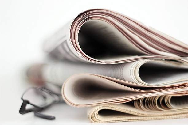 Newpapers A stack of newspapers with glasses. Shallow depth of field. newpapers stock pictures, royalty-free photos & images