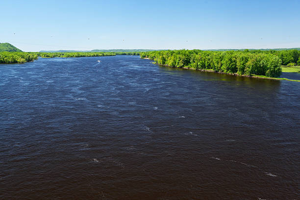 A view looking north of the upper Mississippi River, shot from the Wabasha bridge. To the left is Minnesota, the right Wisconsin, a few power lines cross in the sky.