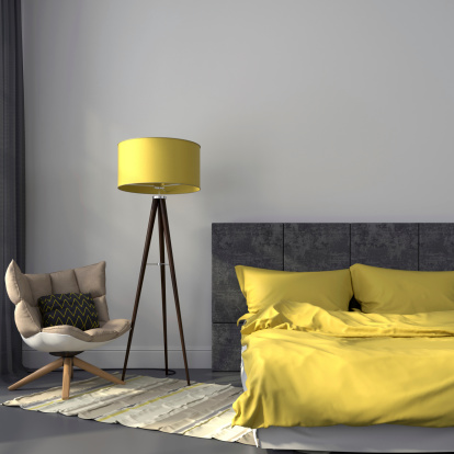 Modern bedroom in gray color and accents on yellow lamp and bedclothes