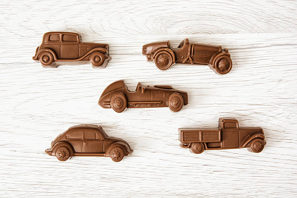 Set of chocolate car figures on wooden background stock photo