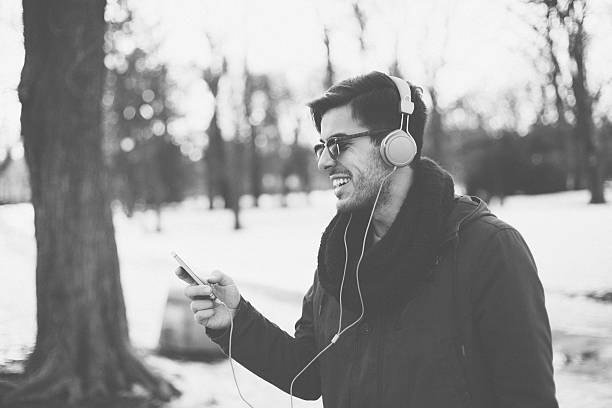 istock Man with headphones texting in the winter park 498759072