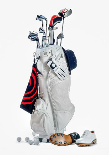 full length shot of a white golf bag with golf clubs, white golf shoes, a white golf driver cap, a golf glove and golf balls on the floor on white background