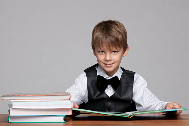 istock Young boy at the desk reads a book 498762262